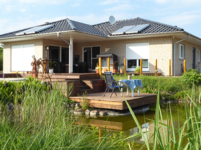 Musterhaus: Außenansicht von Süd-West mit Teich